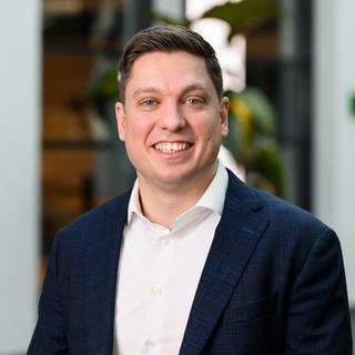a man in a suit and jacket smiling at the camera